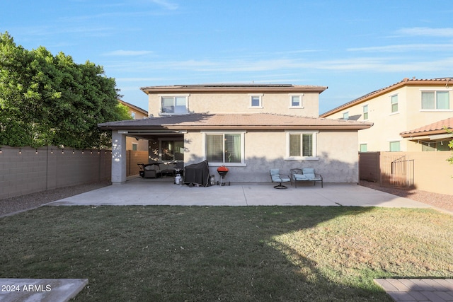 back of house featuring a lawn and a patio