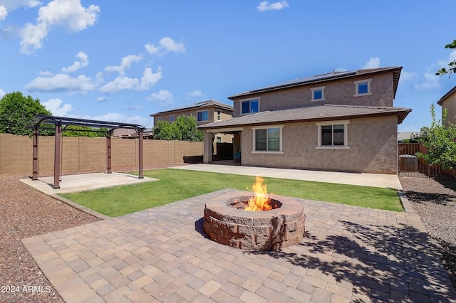 rear view of property with a patio area and a fire pit