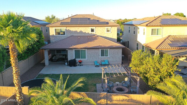 rear view of house with a patio area and solar panels