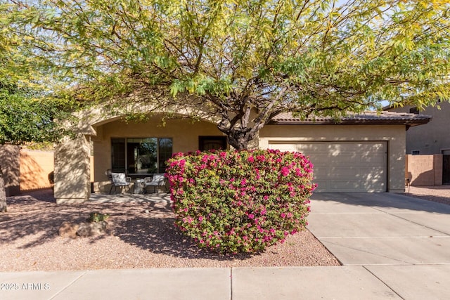 view of front of property featuring a garage, driveway, and stucco siding