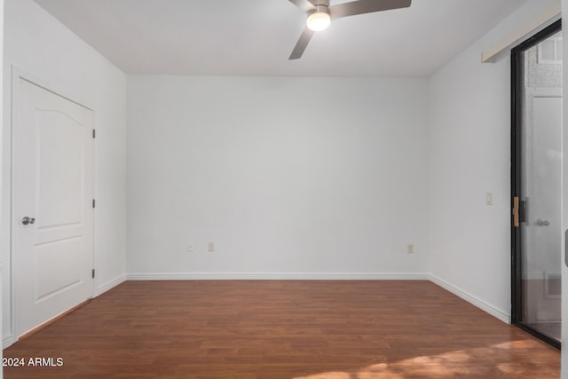 unfurnished bedroom with ceiling fan and dark wood-type flooring