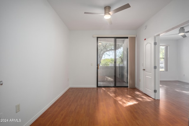 empty room featuring ceiling fan, dark hardwood / wood-style flooring, and a healthy amount of sunlight