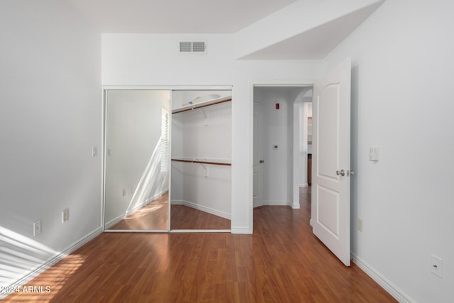 unfurnished bedroom with hardwood / wood-style floors and a closet