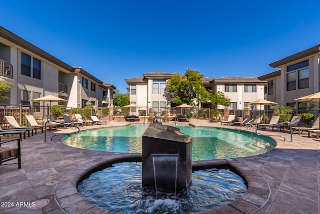 view of swimming pool with a hot tub and a patio area