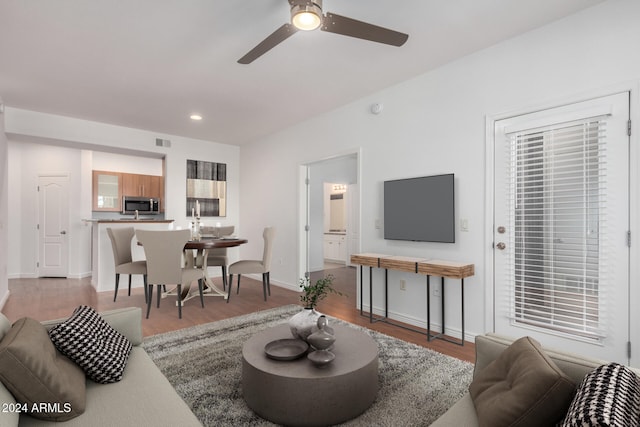 living room featuring ceiling fan and hardwood / wood-style flooring