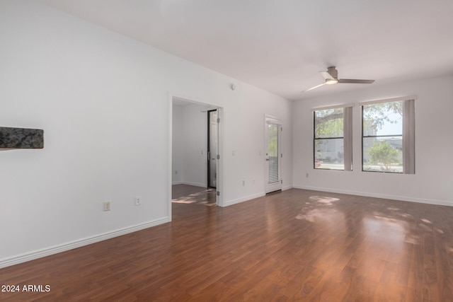 empty room with ceiling fan and dark wood-type flooring