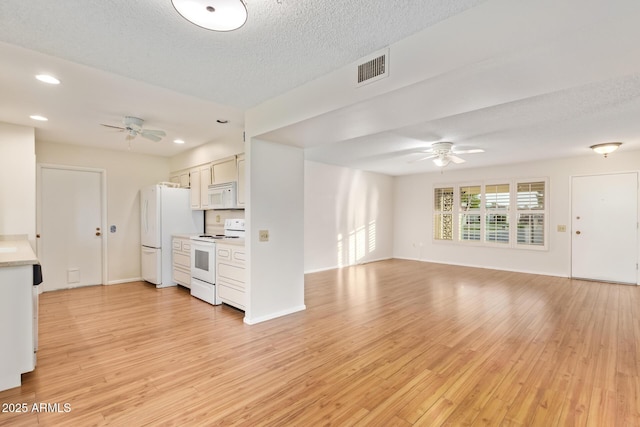 unfurnished living room featuring ceiling fan, light hardwood / wood-style floors, and a textured ceiling