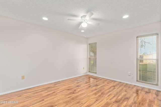 unfurnished room with ceiling fan, light hardwood / wood-style flooring, and a textured ceiling