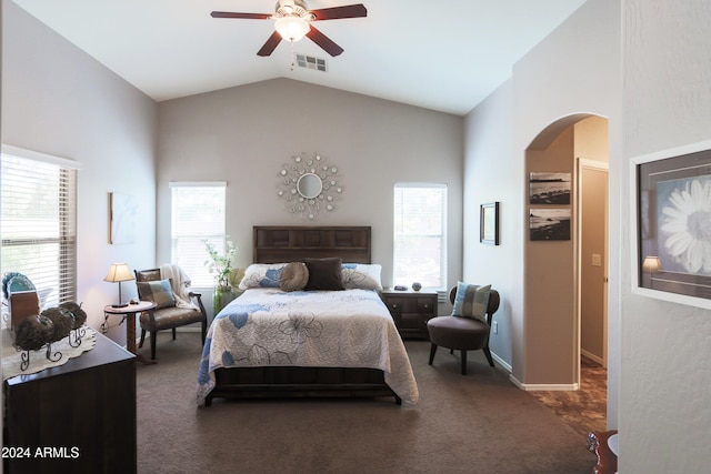 bedroom featuring ceiling fan, lofted ceiling, dark colored carpet, and multiple windows