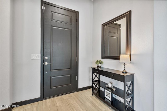 entryway featuring baseboards and light wood finished floors