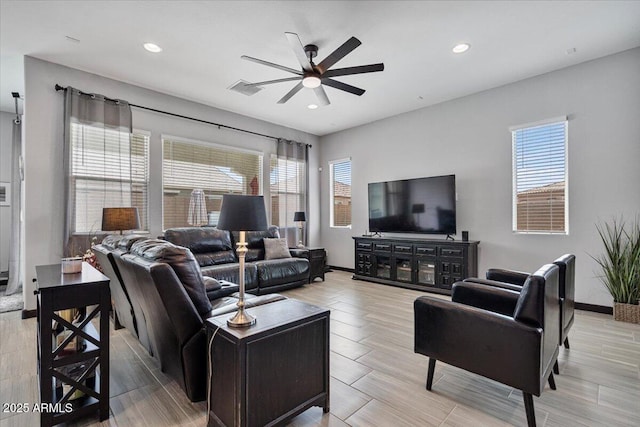 living area featuring a ceiling fan, plenty of natural light, recessed lighting, and baseboards
