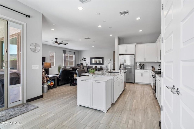 kitchen featuring appliances with stainless steel finishes, recessed lighting, healthy amount of natural light, ceiling fan, and white cabinetry