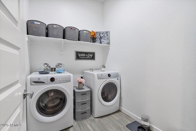 laundry area with washing machine and clothes dryer and baseboards
