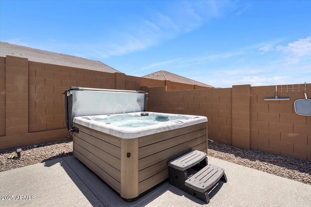 view of patio featuring a hot tub and fence