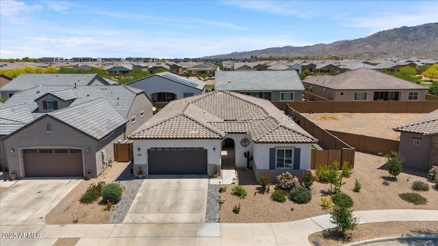 mediterranean / spanish-style house with stucco siding, a residential view, a garage, driveway, and fence