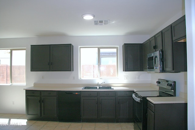 kitchen featuring stainless steel appliances, sink, and light tile patterned floors