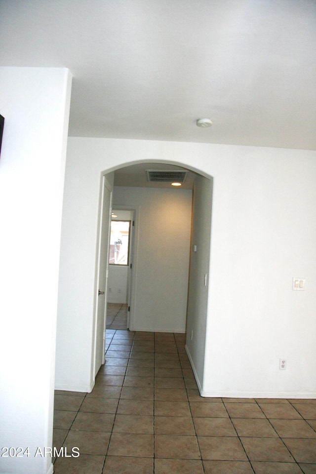 hall featuring dark tile patterned flooring