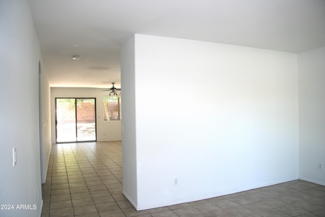 empty room with ceiling fan and light tile patterned floors