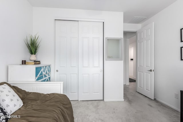 bedroom featuring a closet, visible vents, light colored carpet, and baseboards