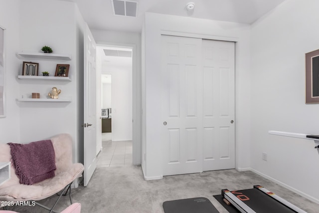 exercise room with baseboards, visible vents, and light carpet