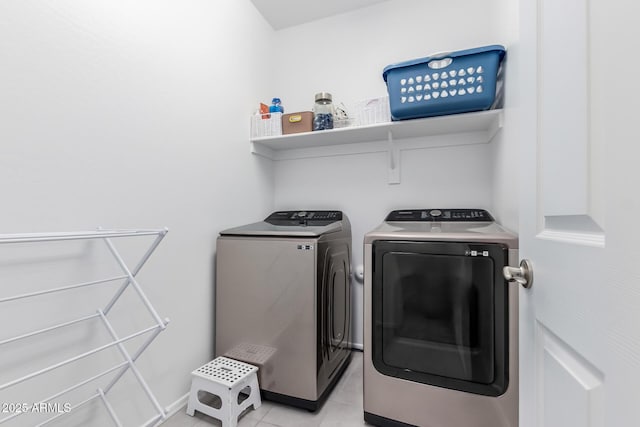 clothes washing area with light tile patterned floors, laundry area, and washing machine and dryer