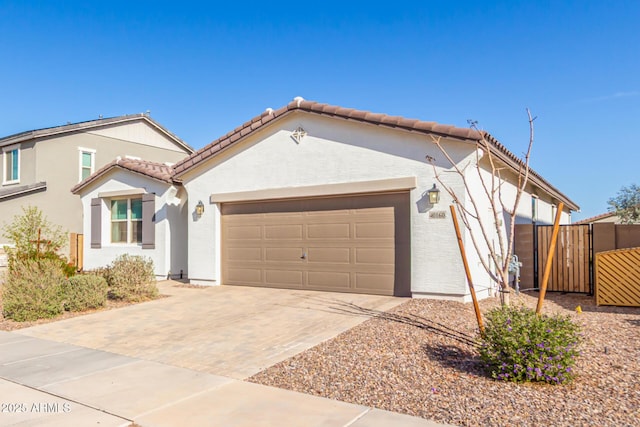 view of front of house with a gate, stucco siding, a garage, a tile roof, and decorative driveway