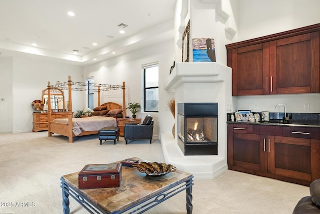 carpeted bedroom with sink and a high ceiling