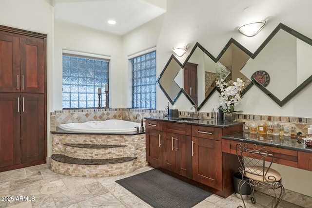 bathroom featuring vanity and a relaxing tiled tub