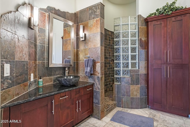 bathroom with vanity, tile walls, and a tile shower