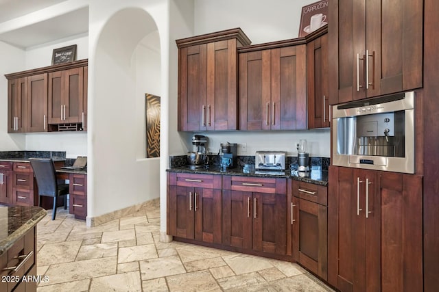 kitchen featuring wall oven and dark stone countertops