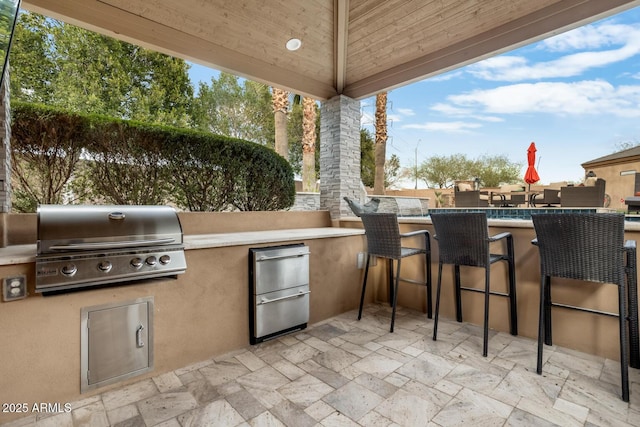 view of patio with an outdoor bar, a grill, and area for grilling