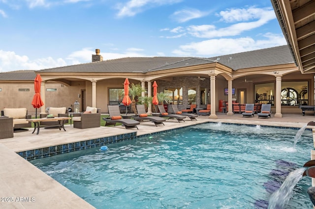 view of swimming pool featuring pool water feature, an outdoor living space, and a patio area