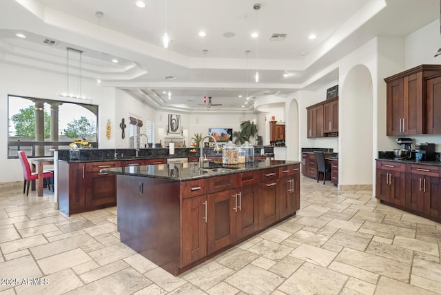 kitchen featuring decorative light fixtures, a raised ceiling, and a large island