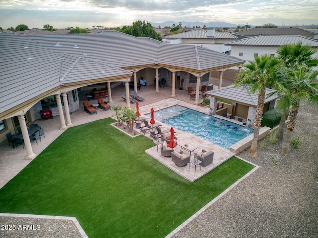 view of swimming pool featuring an outdoor hangout area, a patio, a yard, and an outdoor bar