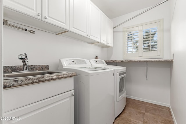 laundry area featuring cabinets, separate washer and dryer, and sink