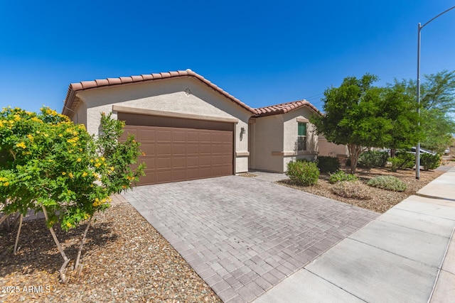 3415 S 75th Dr, Phoenix, AZ 85043 - mediterranean / spanish house featuring a garage, a tile roof, decorative driveway, and stucco siding