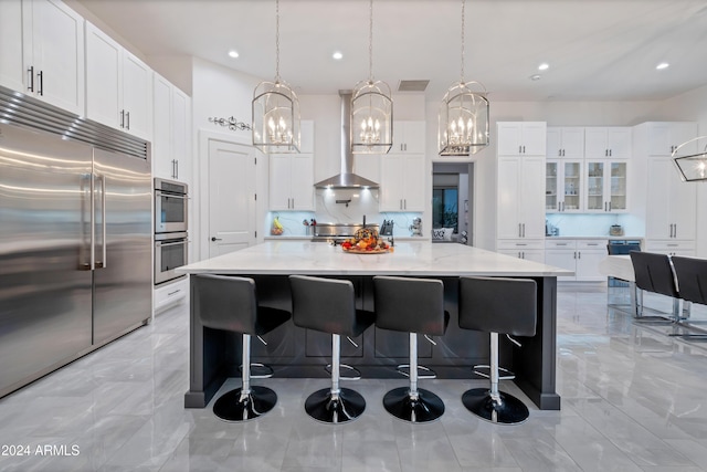 kitchen featuring white cabinets, a large island, a breakfast bar area, and appliances with stainless steel finishes