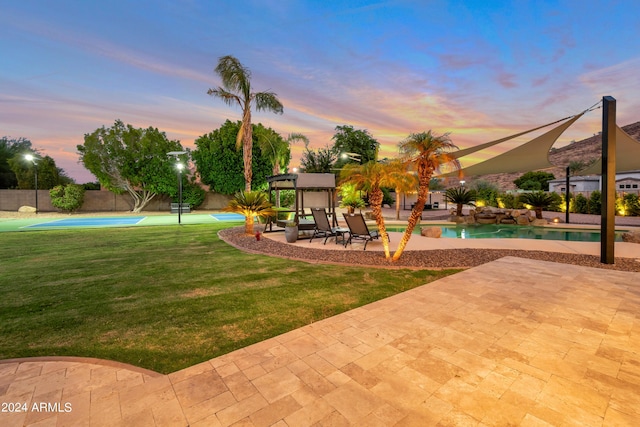 yard at dusk with a patio area