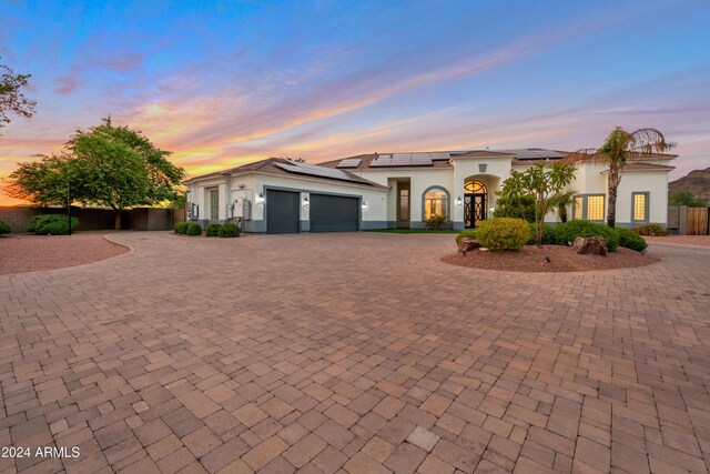 mediterranean / spanish-style home featuring a garage and solar panels