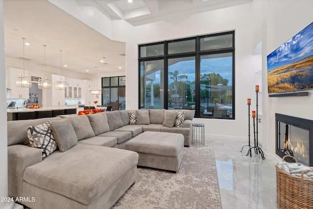 living room with a towering ceiling and coffered ceiling