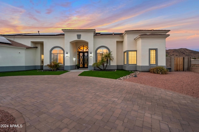 mediterranean / spanish-style home with solar panels and a mountain view