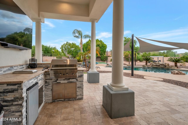 view of patio / terrace featuring a fenced in pool, grilling area, and an outdoor kitchen