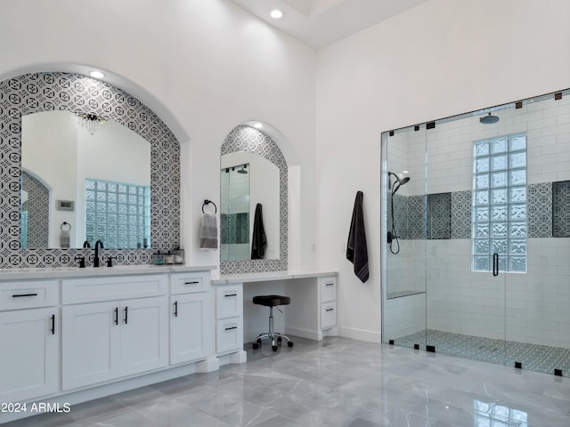 bathroom featuring a shower with door and vanity