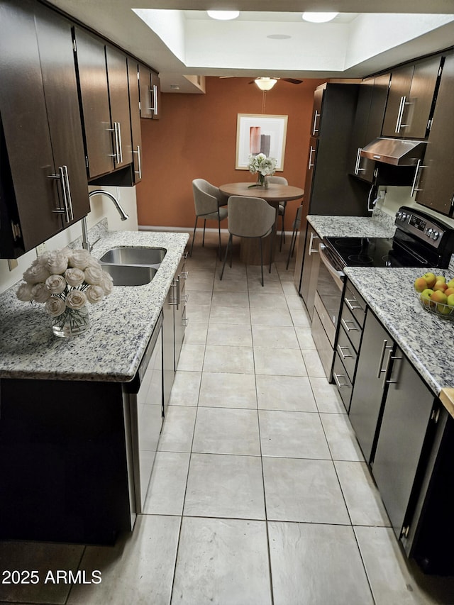 kitchen featuring black electric range oven, sink, stainless steel dishwasher, light tile patterned floors, and light stone counters