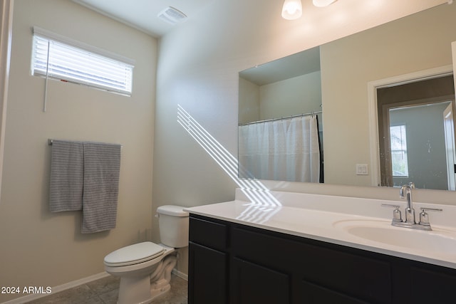 bathroom featuring tile patterned flooring, vanity, and toilet