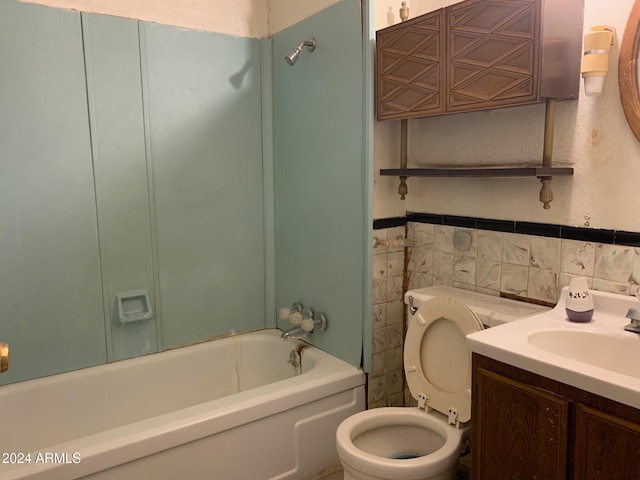 full bathroom featuring  shower combination, vanity, tile walls, and toilet