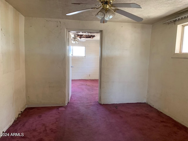 carpeted spare room with a textured ceiling and ceiling fan