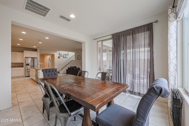 dining area with light tile patterned floors, recessed lighting, visible vents, and stairs