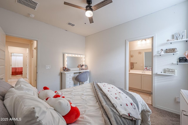 bedroom featuring visible vents, light carpet, ensuite bath, and light tile patterned flooring