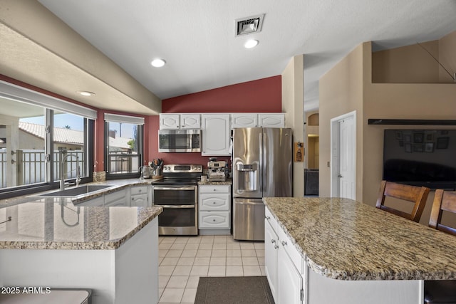 843 E Vera Ln, Tempe, AZ 85284 - kitchen featuring stainless steel appliances, lofted ceiling, white cabinets, a sink, and light tile patterned floors